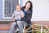 Mother Bess Ong Hold her son Jerry on the front porch of their house