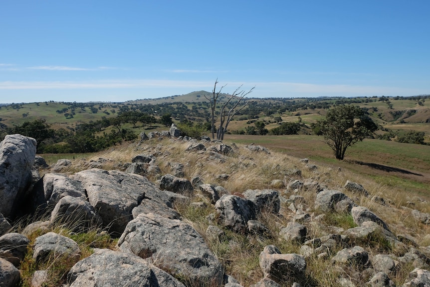 A rocky outcrop in a hilly landscape. 