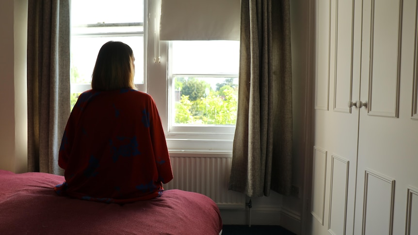 A silhouette of a woman in a bedroom.