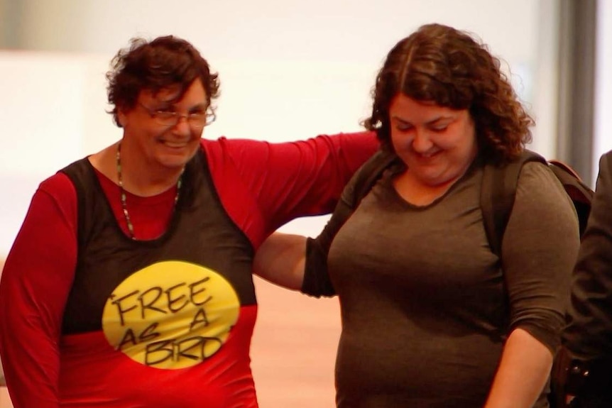 Jane Rosengrave smiles with her arm around another woman's shoulders as she leaves the disability royal commission.