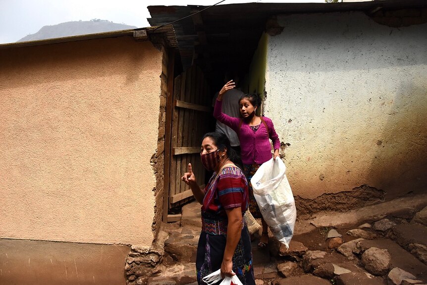 Konojel Program Director Maria Mejia and a colleague distribute aid to a household in San Marcos la Laguna, Guatemala.