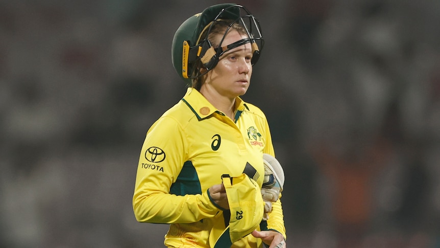 Alyssa Healy with a helmet on top of her hand during Australia's T20I against India.