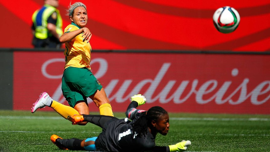 Australia's Kyah Simon scores past Nigerian keeper Precious Dede at the Women's World Cup.