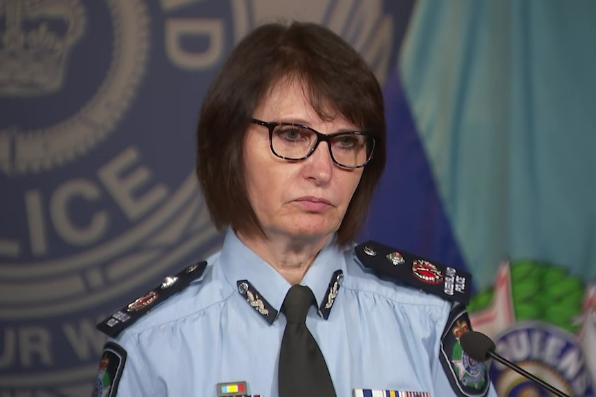 Queensland Police Deputy Commissioner Tracy Linford speaking at press conference, police emblem behind her