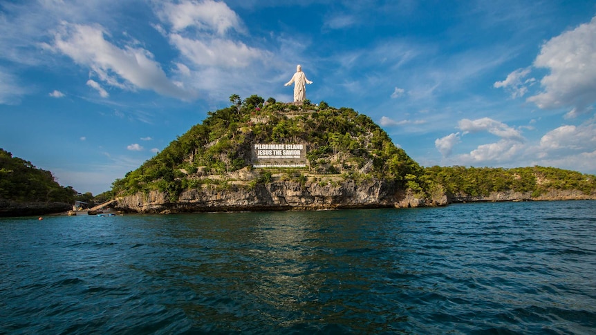 A giant statue of Jesus, on one the islands at the Hundred Islands National Park in the northern Philippines.