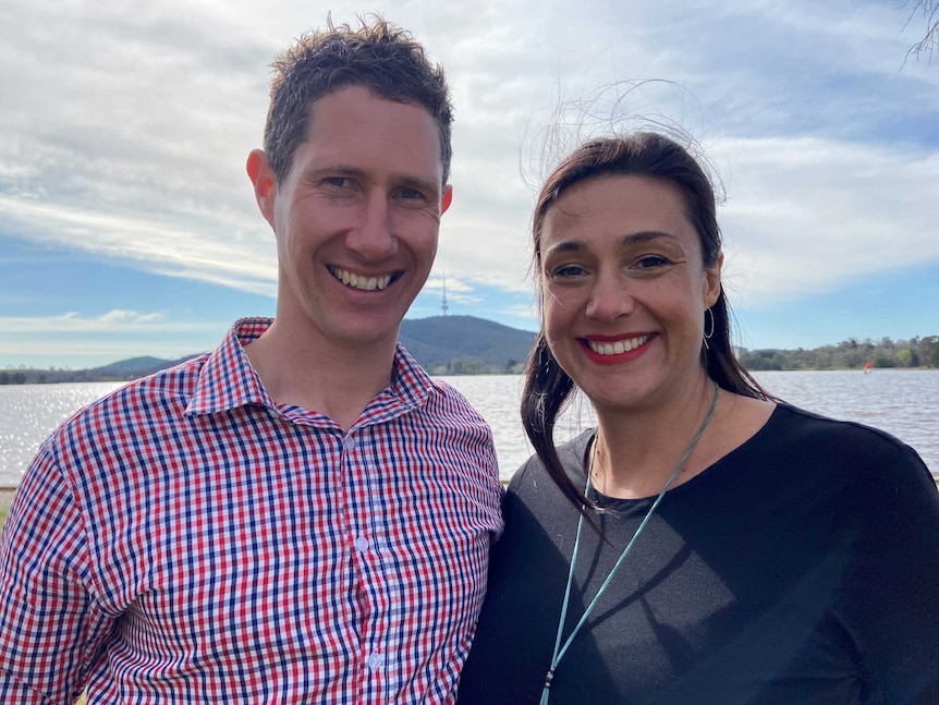 A man and woman on the shores of Lake Burley Griffin in Canberra.