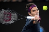 Roger Federer swings a forehand at the tennis ball during his Australian Open clash with Filip Krajinovic.