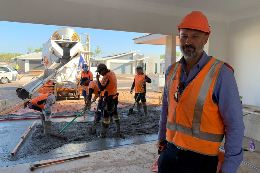 Concreting business owner George Alexopoulos stands with workers in Palmerston, 2019.