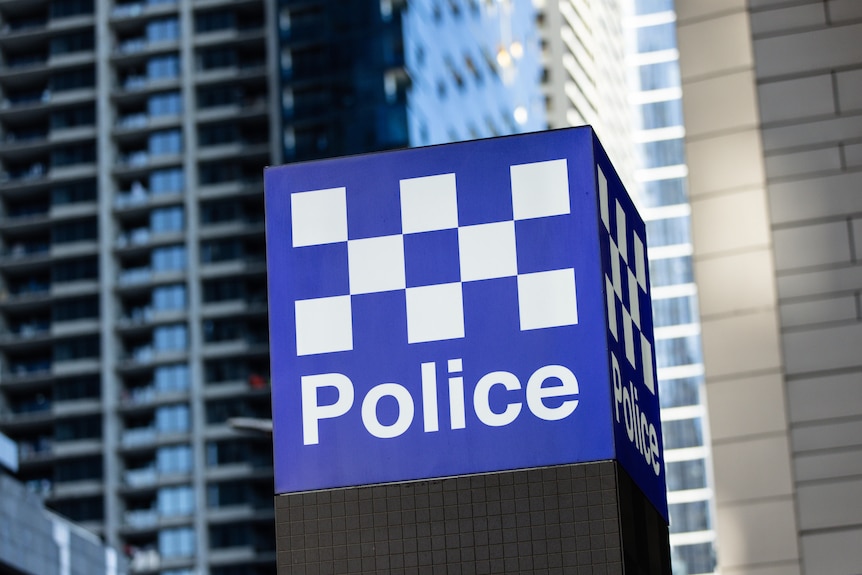 A blue and white Victoria Police sign outside a building. 
