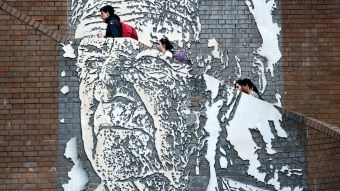 People walk past a mural of Jack Mundey in Sydney.