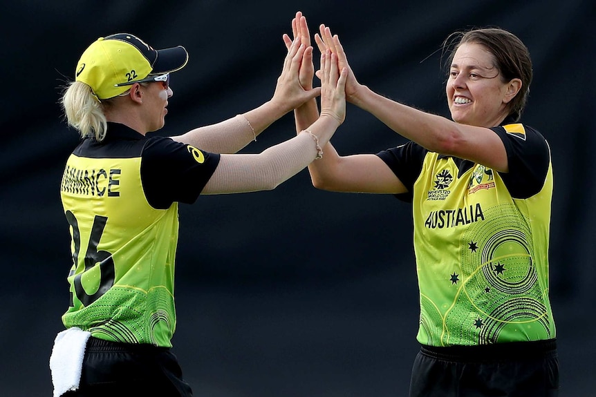 Molly Strano and Delissa Kimmince smile and high five with both hands