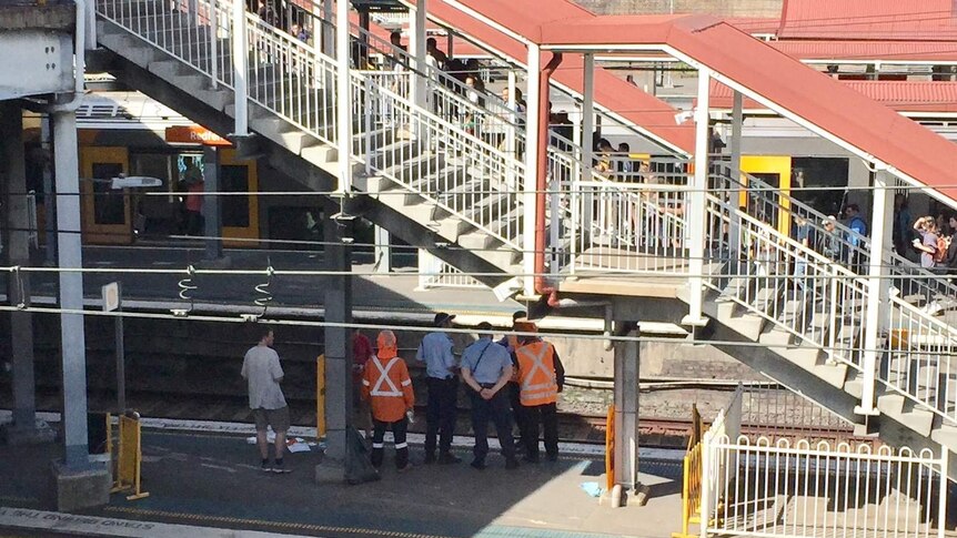 train officers watching people alight at a train station