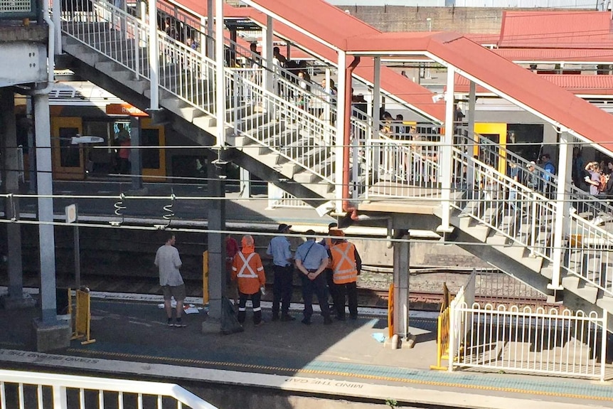 train officers watching people alight at a train station