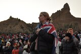 A woman drapes herself with a flag at the 2012 dawn service in Gallipoli.