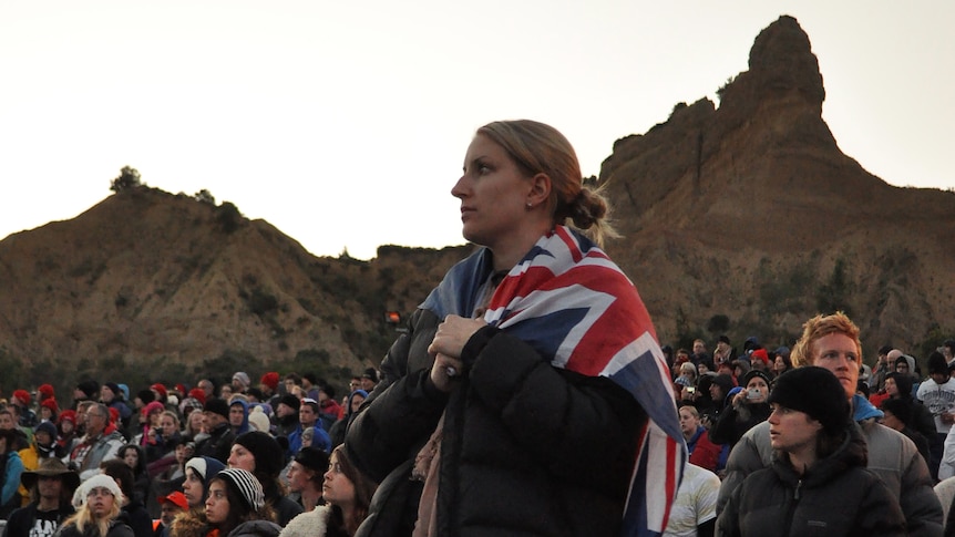 A woman drapes herself with a flag at the 2012 dawn service in Gallipoli.