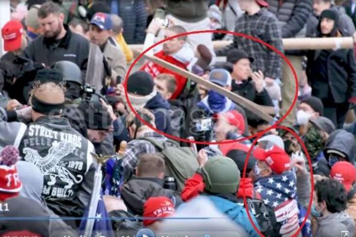 a video screenshot showing a crowd of capitol rioters and two red circles around a plank in the air and Robert Scott Palmer