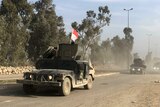 A column of Iraqi defence force units drives along a road in western Mosul.