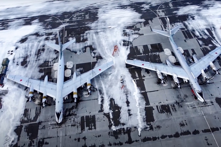 Russia bomber planes sit on a runway covered in snow