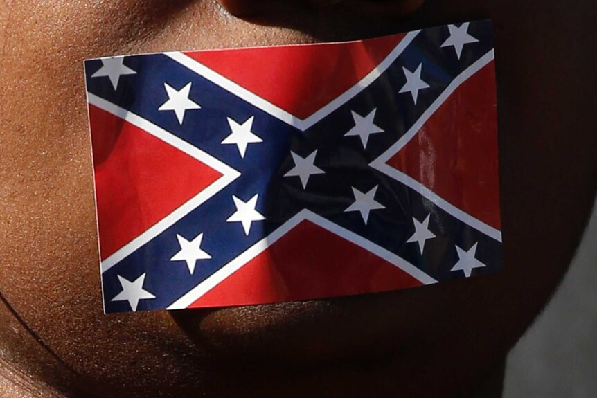 Close up view of the bottom half of a woman's face, with a confederate flag sticker over her mouth