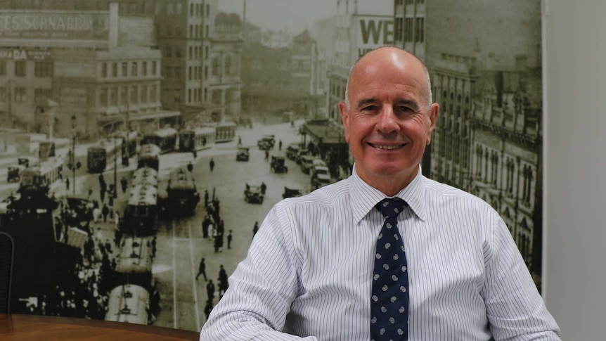 Real estate agent Malcolm Gunning smiles for the camera at his office in Sydney