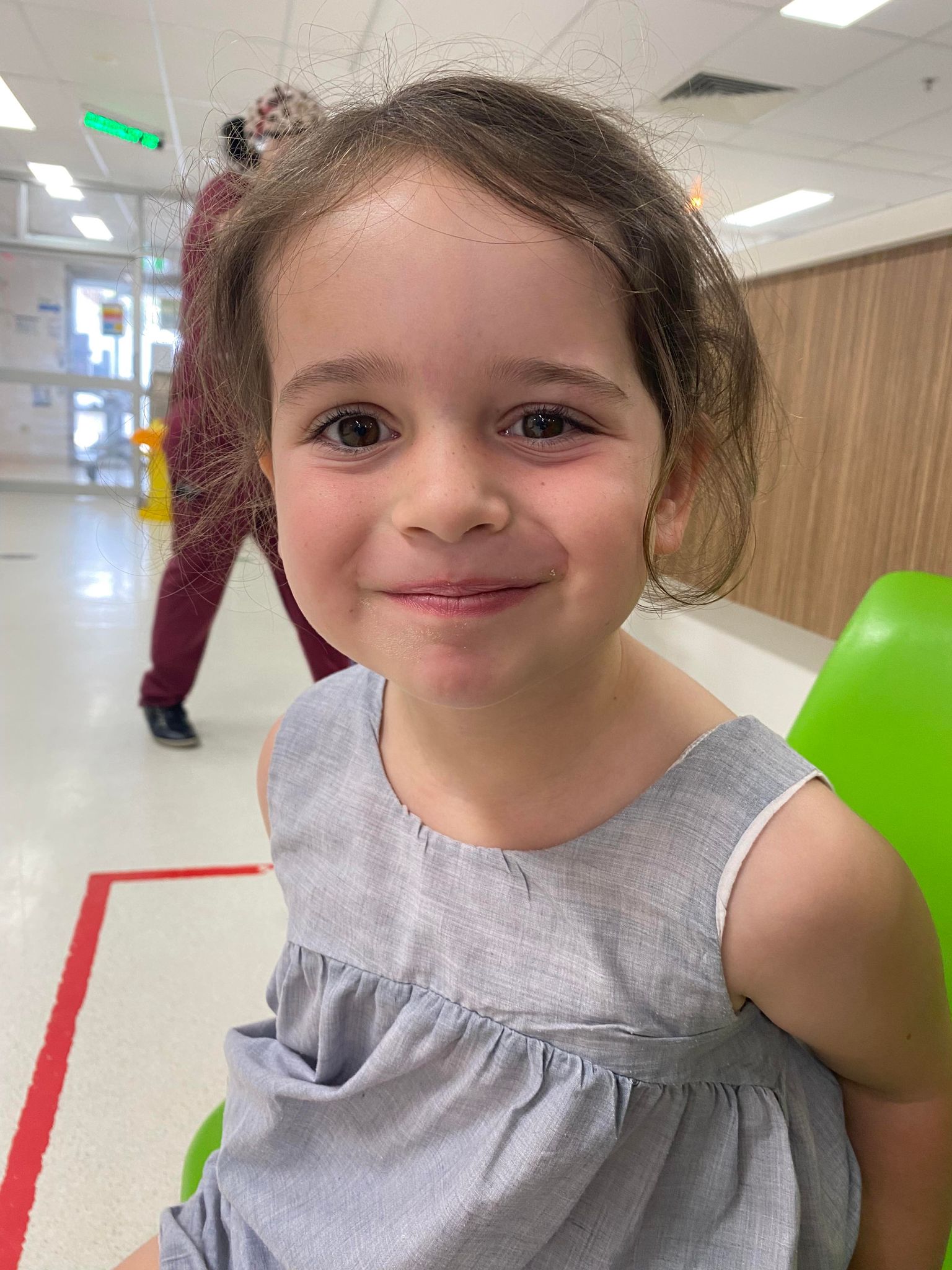 Close up for Arlo's face, brown hair, brown eyes, slight smile, slight droop in right side of her face.