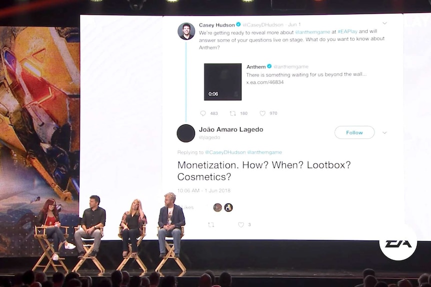 Bioware's Mark Darrah on stage with others as a tweet question about loot boxes is displayed on a big screen behind panelists.