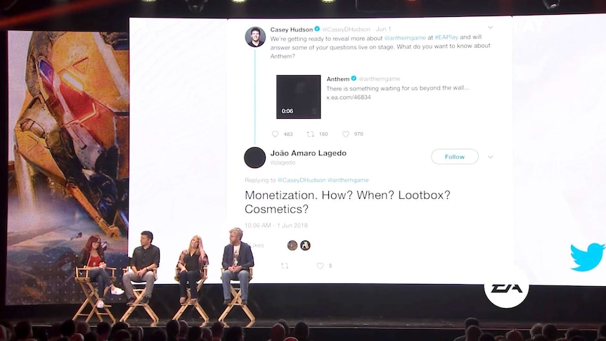 Bioware's Mark Darrah on stage with others as a tweet question about loot boxes is displayed on a big screen behind panelists.