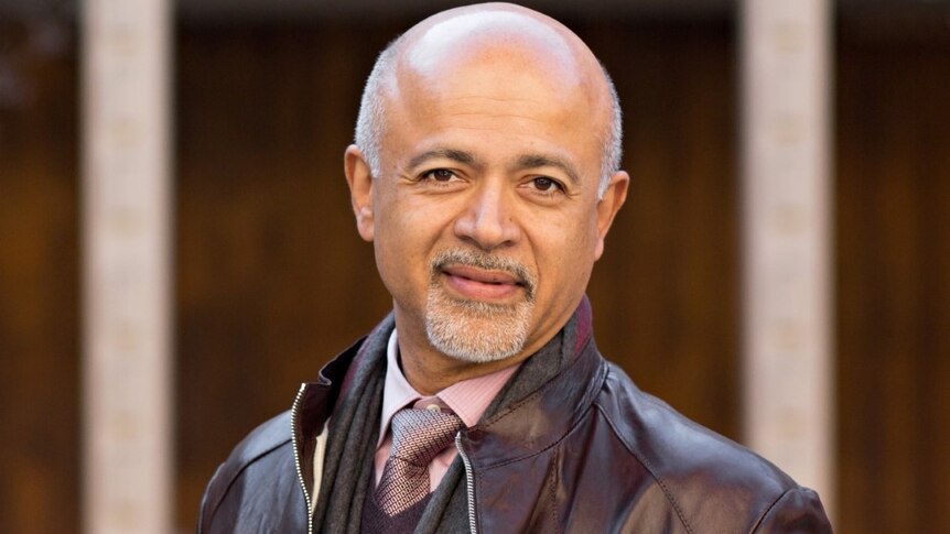 Abraham Verghese in a leather jacket standing