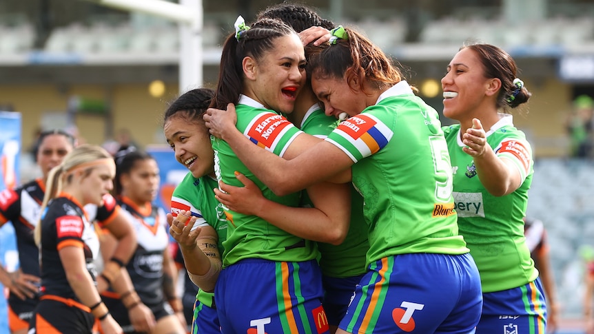 Canberra Raiders NRLW players embrace as they celebrate a try against Wests Tigers.