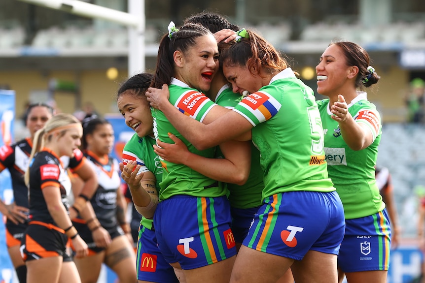 Canberra Raiders NRLW players embrace as they celebrate a try against Wests Tigers.
