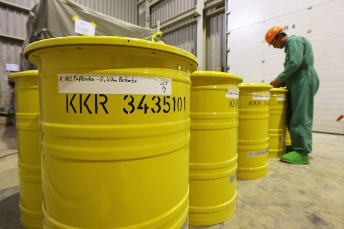 A worker labels yellow barrels containing potentially radioactive material at the former Rheinsberg nuclear power plant
