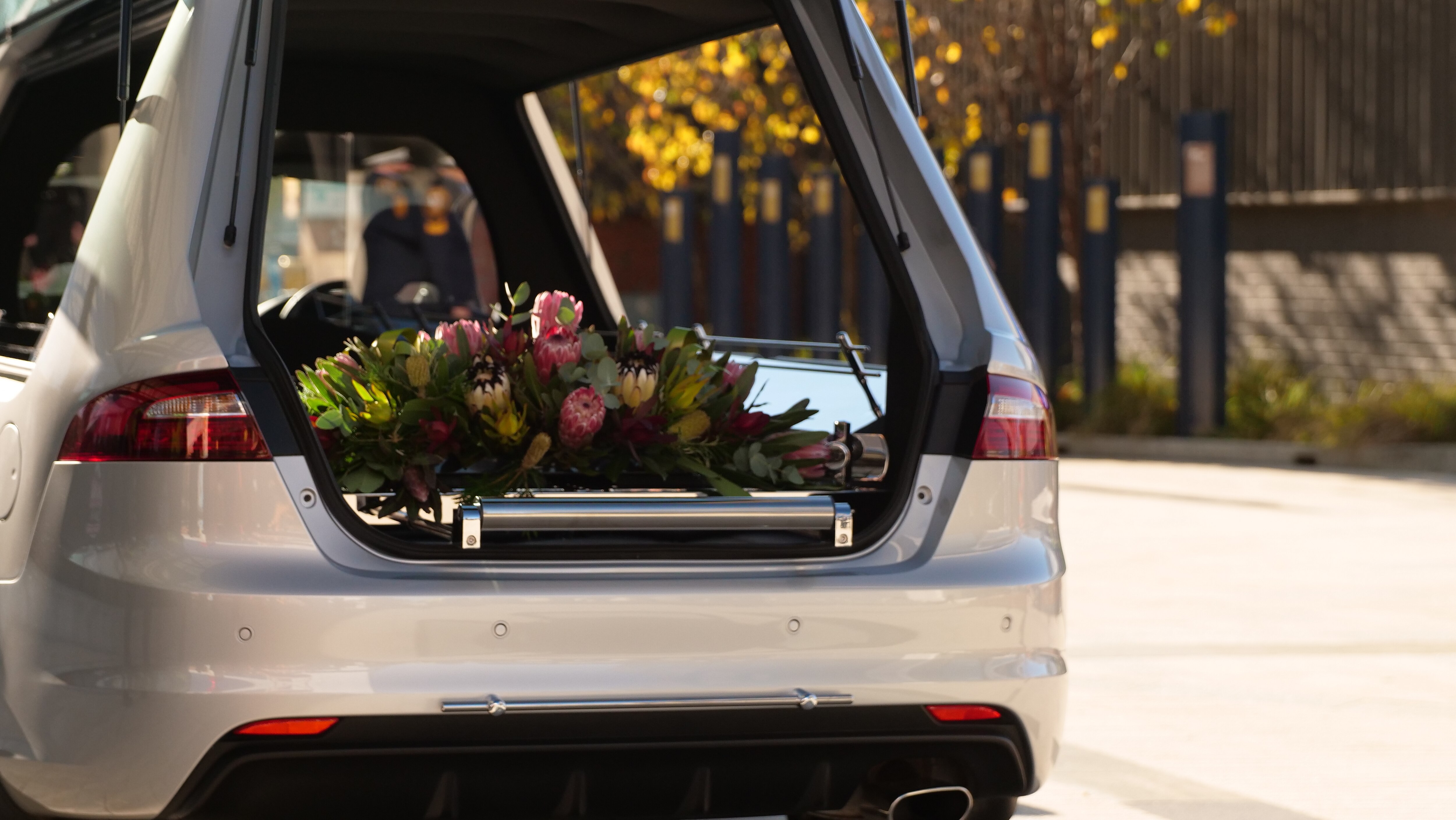 a coffin laden with flowers in car