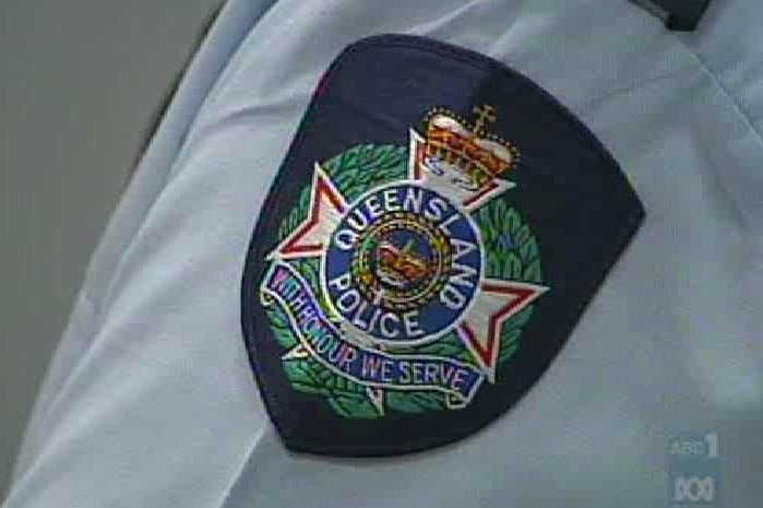 A close-up of a Queensland Police logo on a uniform