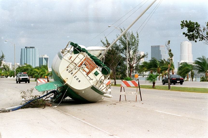 A boat lies on its side on a highway.