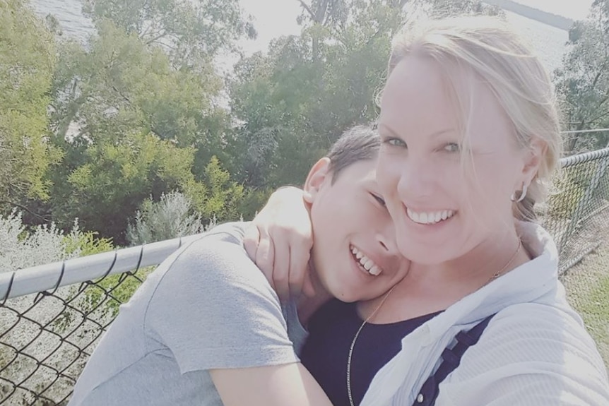 Teenager Jake Cooper hugs his mum Renee in a park overlooking the ocean.