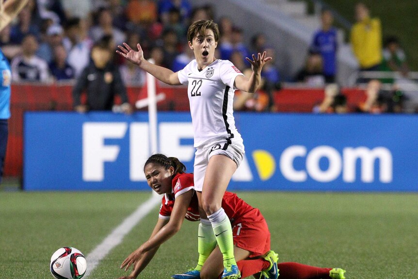 Tight encounter ... Meghan Klingenberg reacts after challenging China's Wang Lisi of China for possession