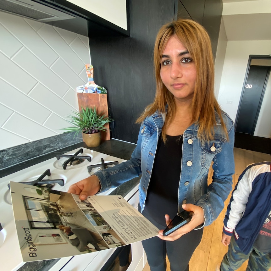 Neha Dahiya stands while looking at a property advertisement.