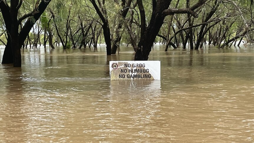 A sign saying 'no grog, no humbug, no gambling' in a flooded park
