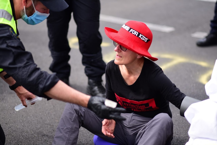 An Extinction Rebellion protester is removed from the road.