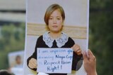 Protester holds photo of woman with short hair at protest