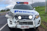 A police 4wd with its lights flashing and front light smashed