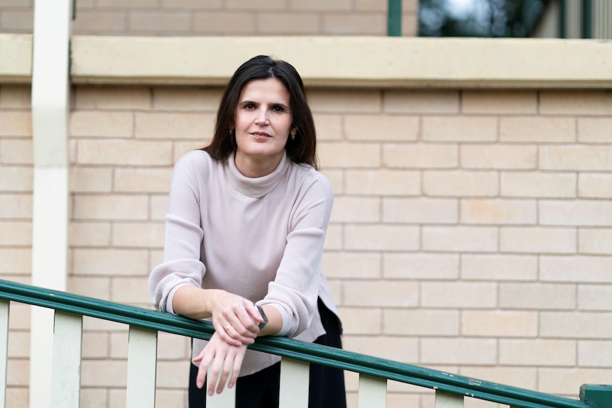 A woman poses in front of a building