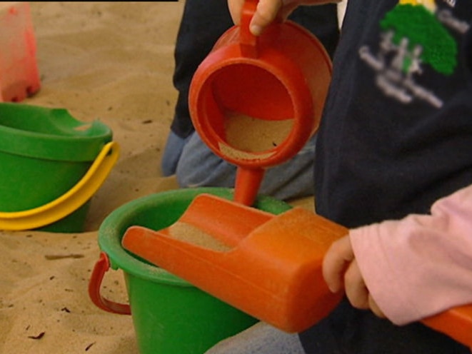 Children in sandpit playing with toys