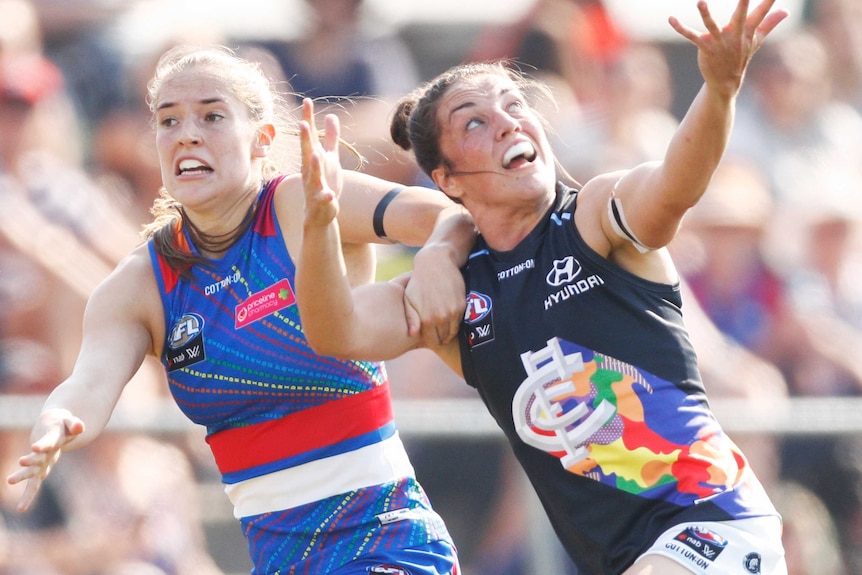 Two AFLW compete for a ball, which is out of shot.