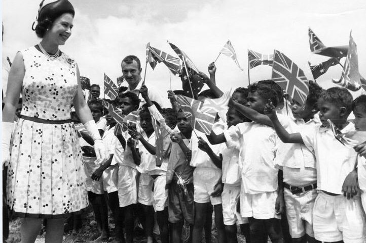 The Queen smiles at indigenous schoolchildren waving union jacks