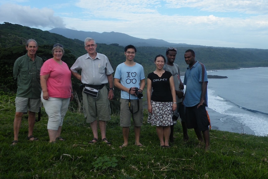 Group of volunteers standing on a beach cliff