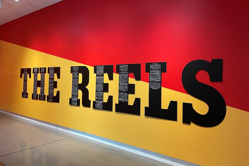 A large blue and red banner emblazoned with the words "The Reels".