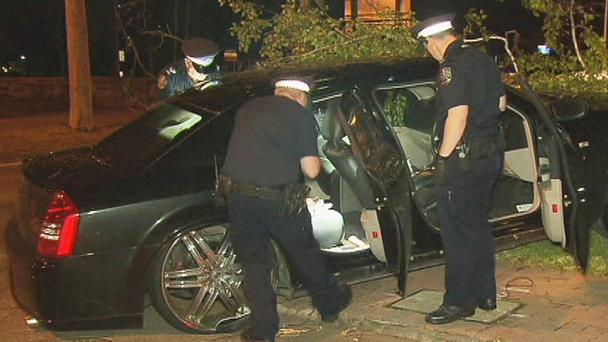 Police look through the crashed Chrysler