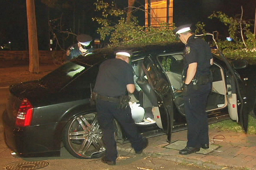 Police look through the crashed Chrysler