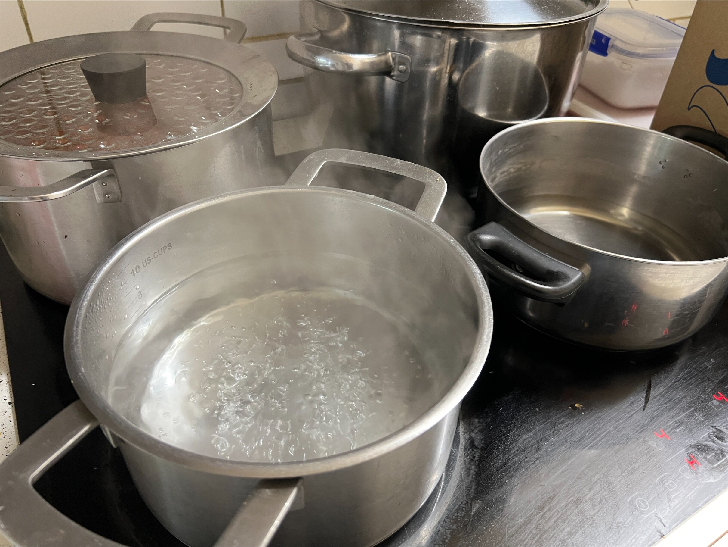 Three pots on a stove boiling water